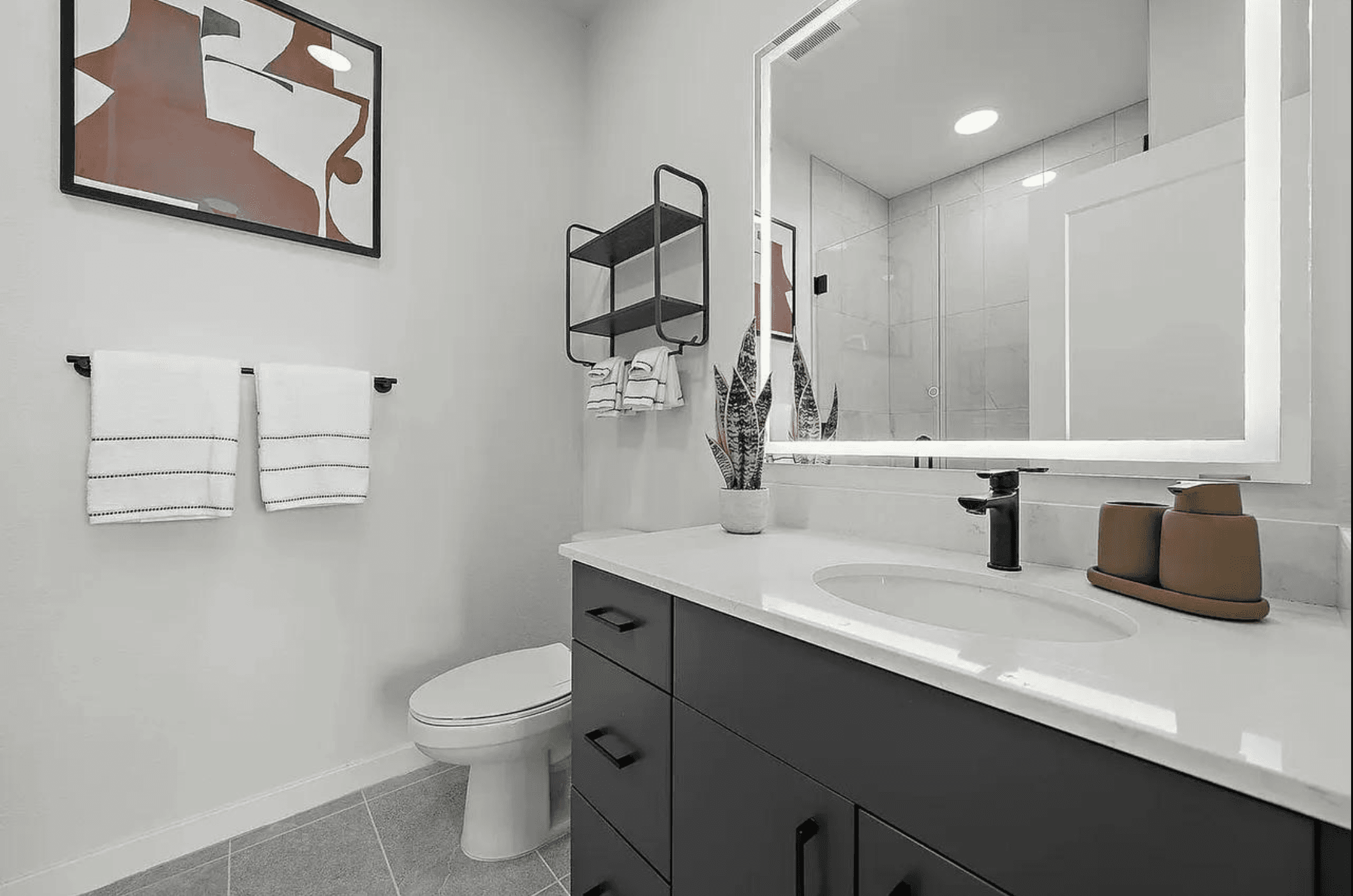 A finished bathroom with a clean vanity, mirror, and folded towels